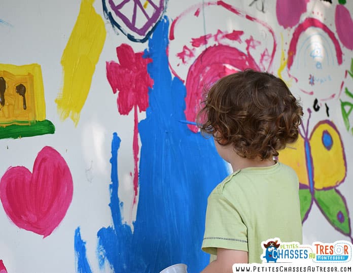 Enfant qui fait de la peinture sur un mur