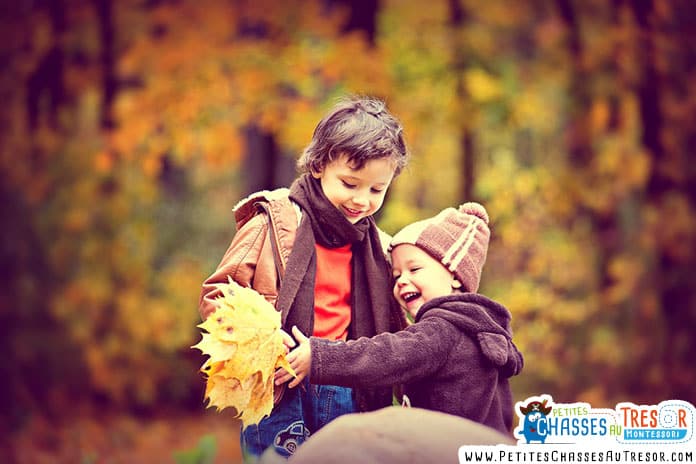 des enfants jouent avec les feuilles en automne