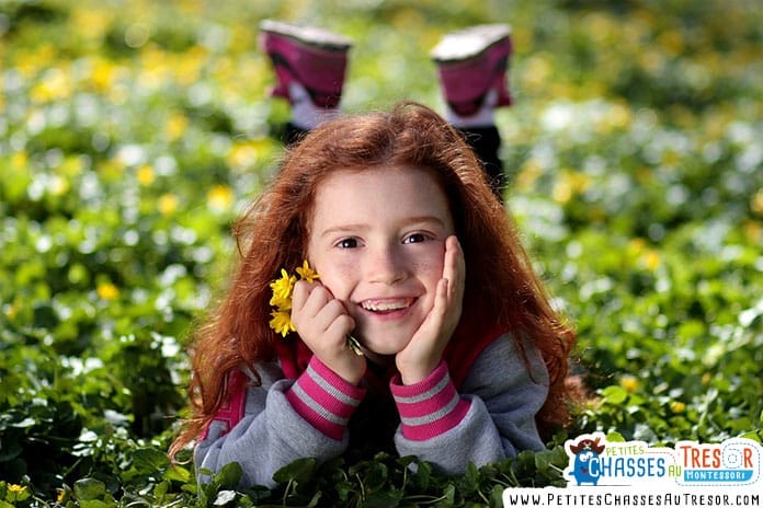 une petite fille est allongé dans un champ d'herbe